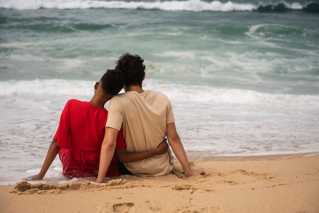 Pareja romántica mostrando afecto en la playa cerca del océano