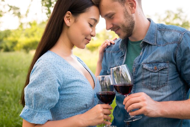 Pareja romántica multiétnica con copas de vino