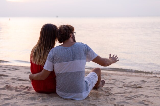 Pareja romántica en la playa al atardecer