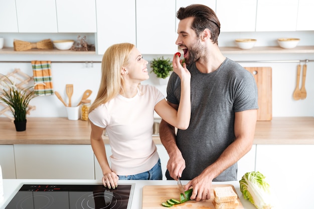 Pareja romántica preparando la cena en la cocina en casa