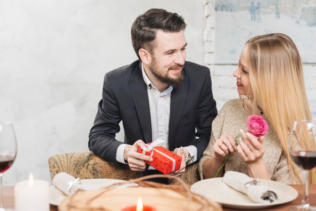 Pareja romántica con presente y rosa.