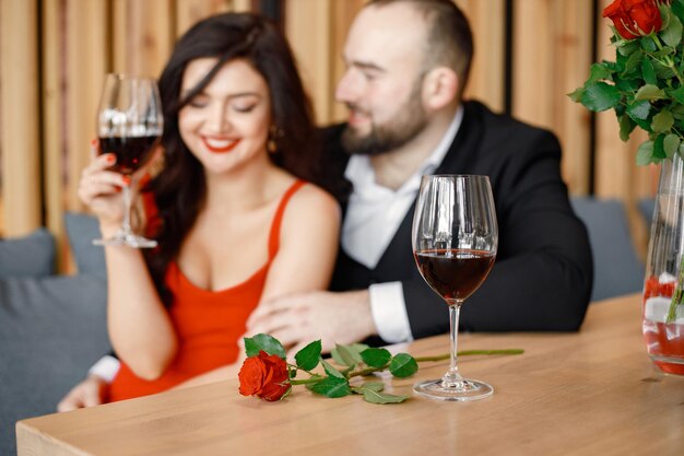 Pareja romántica sentada en un restaurante en una cita y bebiendo vino