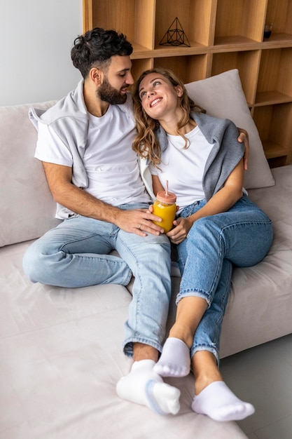 Foto gratuita pareja romántica en el sofá en casa con jugo