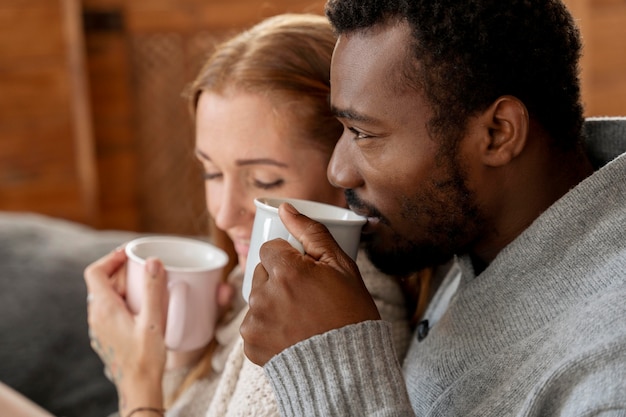 Pareja romántica con tazas de cerca