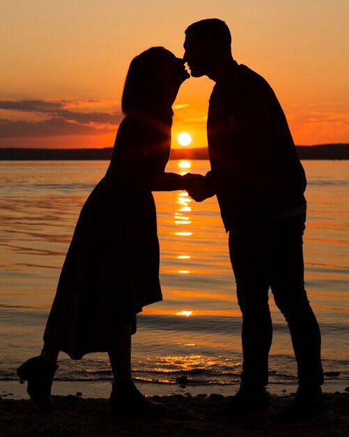 Pareja romántica de tiro completo al atardecer