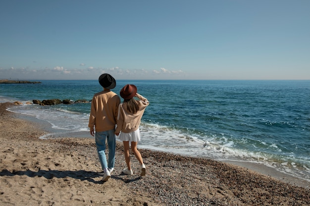 Foto gratuita pareja romántica de tiro completo en la playa