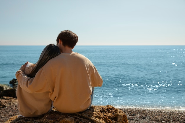 Foto gratuita pareja romántica de tiro completo en la playa