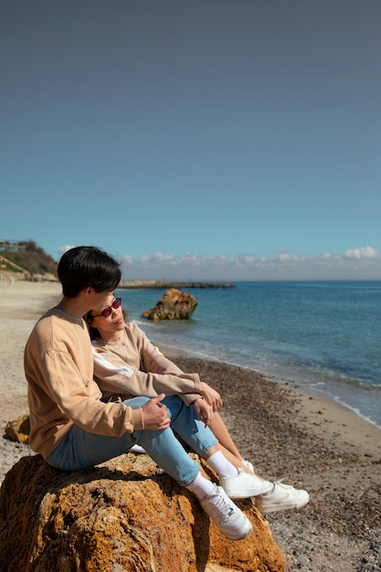 Foto gratuita pareja romántica de tiro completo en la playa