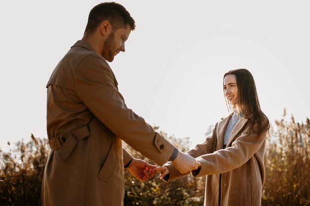 Pareja romántica de tiro medio cogidos de la mano