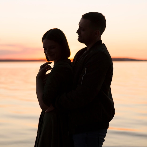 Pareja romántica de tiro medio en la playa