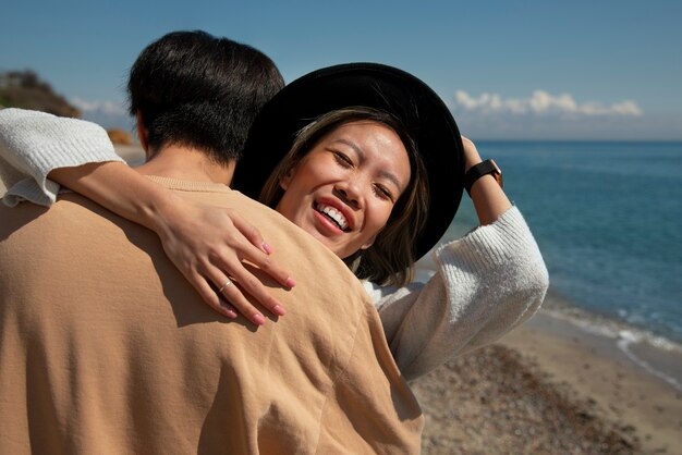 Foto gratuita pareja romántica de tiro medio en la playa