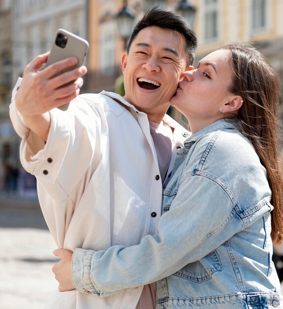 Pareja romántica de tiro medio tomando selfie