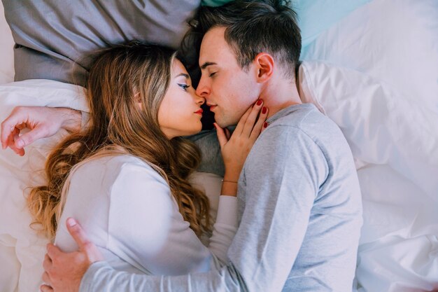 Pareja romántica tumbada en la cama