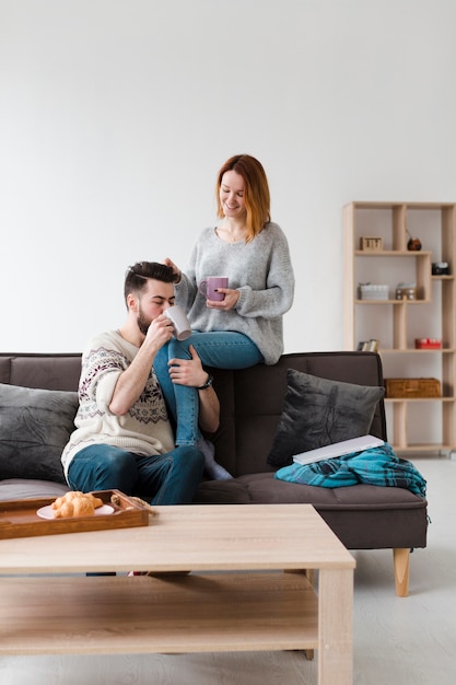 Pareja en la sala bebiendo café por la mañana