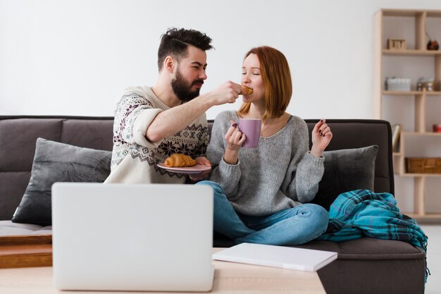 Pareja en la sala de comer croissants