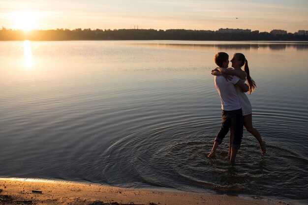 Pareja, en, salida del sol, en la playa