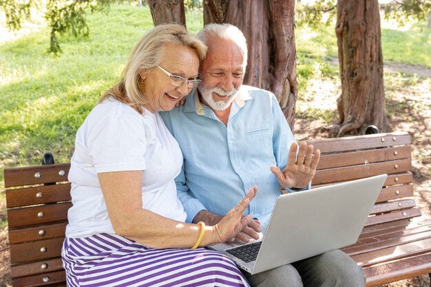 Pareja saludando a alguien en la computadora portátil