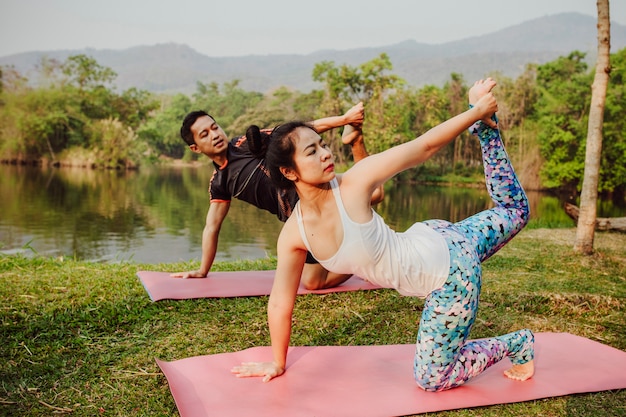 Pareja sana, yoga y lago