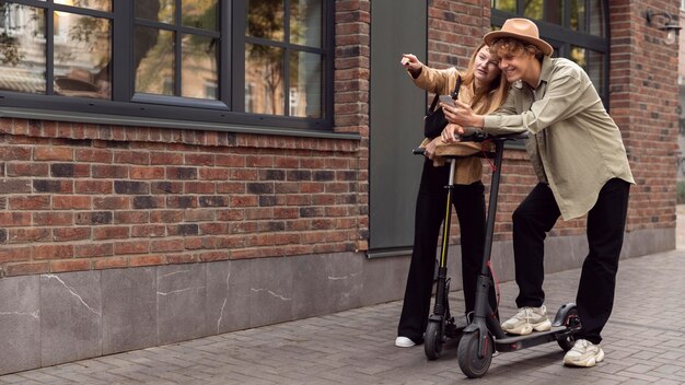 Pareja con scooters eléctricos al aire libre