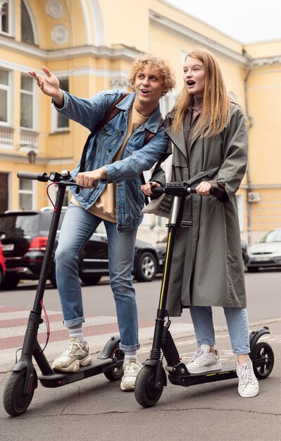 Pareja en scooters eléctricos en la ciudad