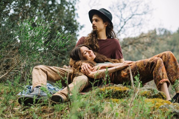 Pareja de senderistas enamorados sentada en la naturaleza