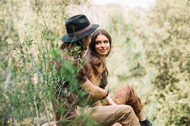 Pareja de senderistas enamorados sentada en la naturaleza