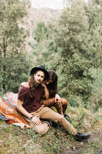 Pareja de senderistas enamorados sentada en la naturaleza