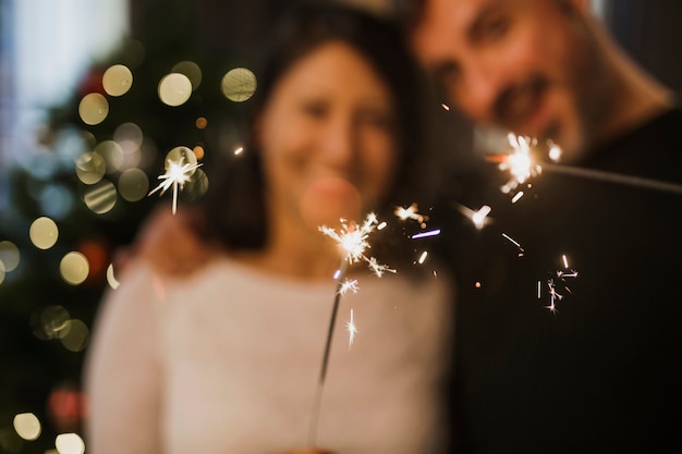 Pareja senior alegre celebración de fuegos artificiales