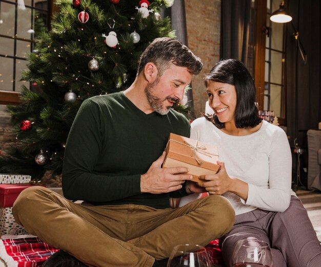 Pareja senior alegre intercambiando regalos