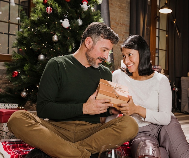 Pareja senior alegre intercambiando regalos