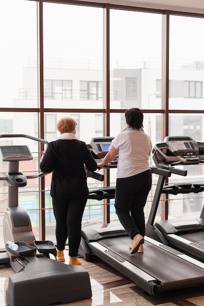 Foto gratuita pareja senior de alto ángulo en cinta de correr