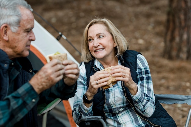 Pareja senior romántica haciendo un picnic en el camping