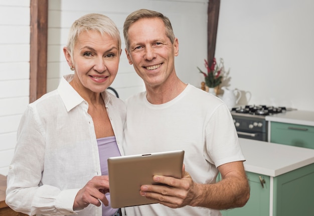 Pareja senior sonriente sosteniendo su tableta