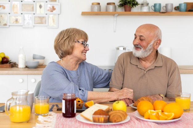 Pareja senior sonriente de tiro medio en la mesa