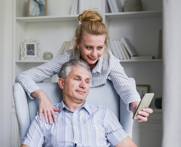 Pareja senior sonriente tomando un selfie juntos