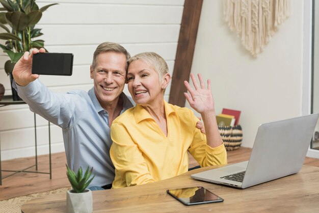 Pareja senior sonriente tomando un selfie juntos