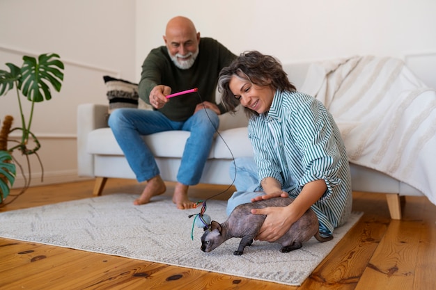 Pareja senior de tiro completo con gato en casa