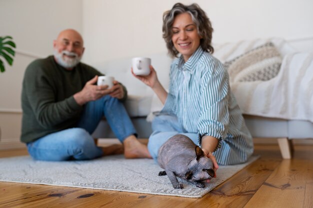 Pareja senior de tiro completo con gato en casa