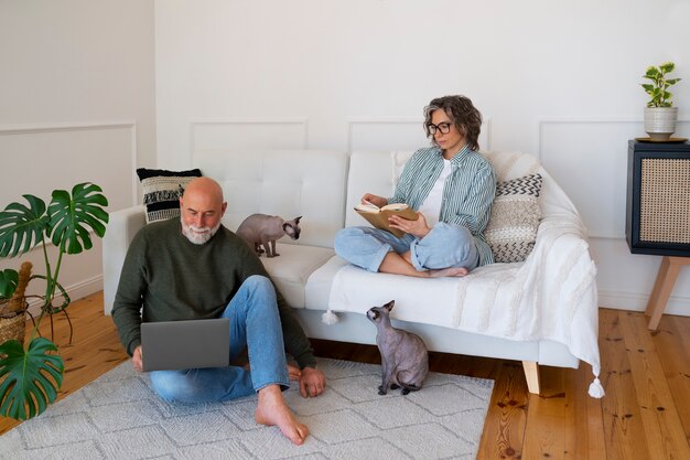 Pareja senior de tiro completo con gato en casa