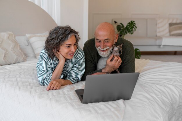 Pareja senior de tiro completo con gato en casa