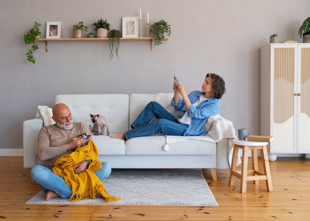 Foto gratuita pareja senior de tiro completo con gato en casa