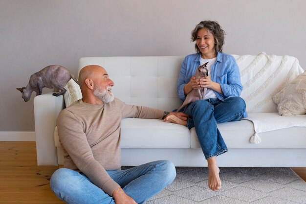 Pareja senior de tiro completo con gato en casa