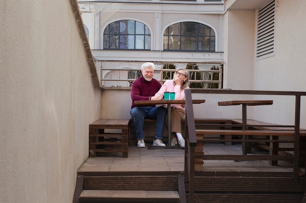 Pareja senior de tiro completo sentados juntos