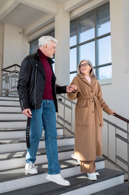 Pareja senior de tiro completo tomados de la mano