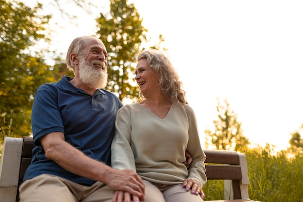 Foto gratuita pareja senior de tiro medio en un banco