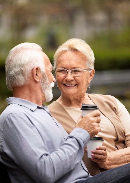 Pareja senior de tiro medio con café