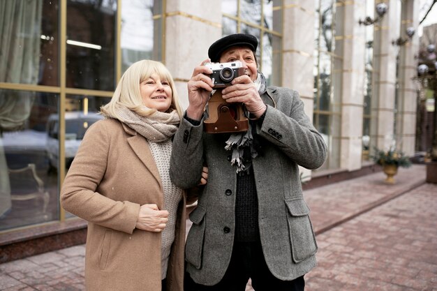 Pareja senior de tiro medio con cámara de fotos