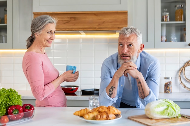 Pareja senior de tiro medio con comida