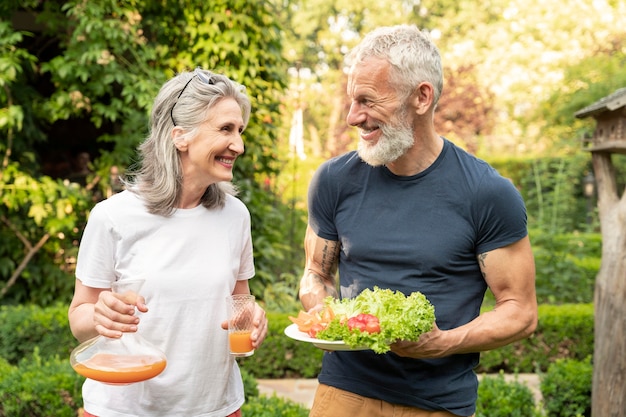 Pareja senior de tiro medio con comida