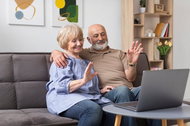 Pareja senior de tiro medio con dispositivo